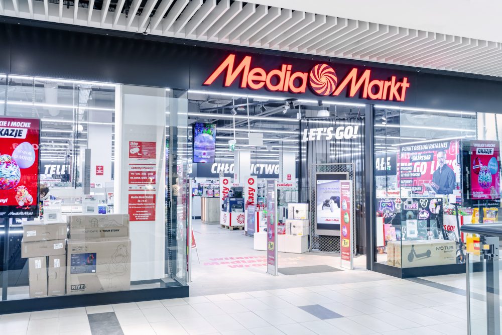 Szerokie, otwarte wejście do sklepu Media Markt. Nad wejściem widnieje duże, charakterystyczne czerwone logo marki na czarnym tle.