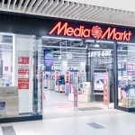 Szerokie, otwarte wejście do sklepu Media Markt. Nad wejściem widnieje duże, charakterystyczne czerwone logo marki na czarnym tle.