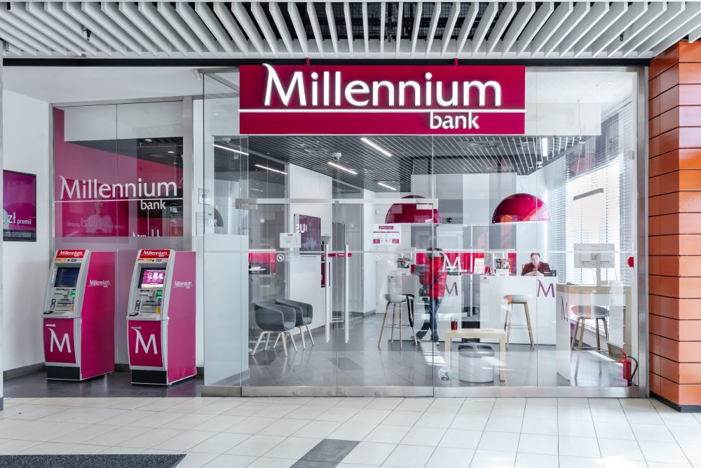Widok na front i wejście do oddziału Banku Millennium. Nad wejściem widoczne charakterystyczne logo w kolorze fuksji