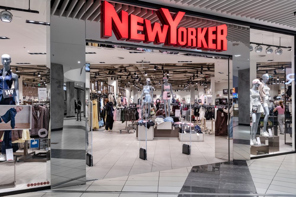 Perspektywa boczna na wejście i witrynę salonu New Yorker.