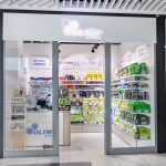Frontowy widok na punkt Olimp Store. Nad wejściem widoczne charakterystyczne, dynamiczne logo marki.