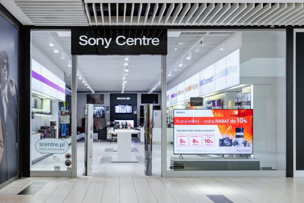 : Widok na front salonu Sony Centre. Nad wejściem widnieje klasyczne, białe logo Sony na ciemnym tle.