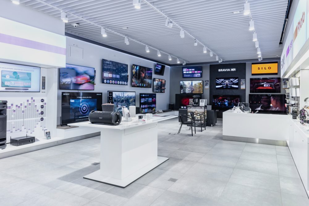 Wnętrze salonu Sony Centre z ekspozycją dużych telewizorów zamontowanych na ścianach.