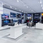 Wnętrze salonu Sony Centre z ekspozycją dużych telewizorów zamontowanych na ścianach.