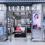 Widok na frontową część salonu Wólczanka. Nad wejściem znajduje się klasyczne, czarne logo marki na jasnym tle.