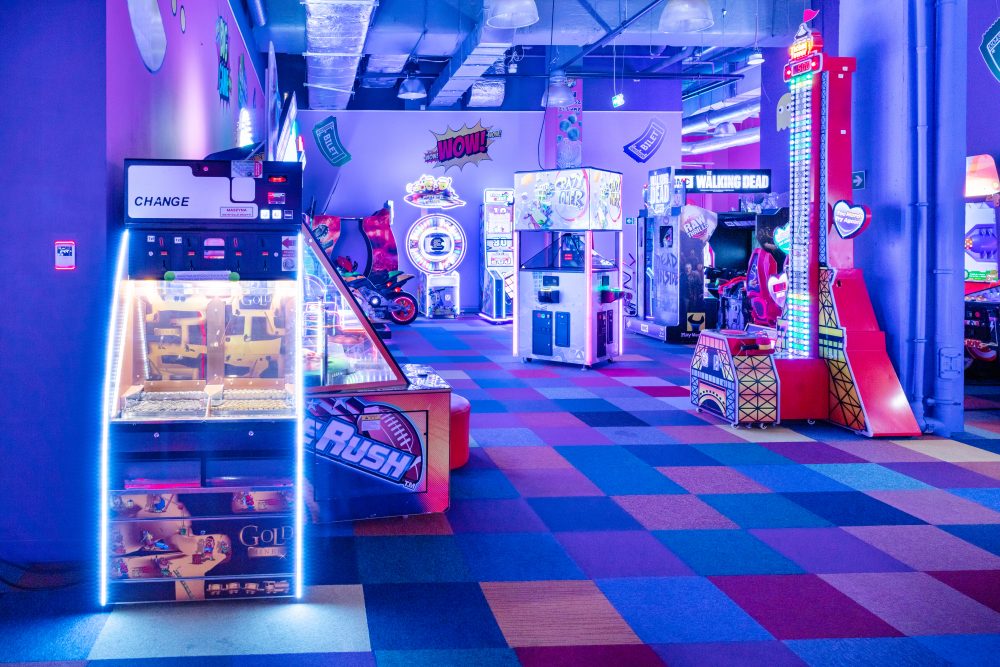 Szerokie ujęcie wnętrza salonu gier Fox Games Arcade. Widoczne rzędy różnorodnych automatów ustawionych wzdłuż ścian i w centralnej części lokalu.