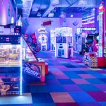 Szerokie ujęcie wnętrza salonu gier Fox Games Arcade. Widoczne rzędy różnorodnych automatów ustawionych wzdłuż ścian i w centralnej części lokalu.