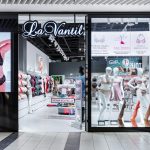 Elegancki front salonu La Vanity w Pasażu Grunwaldzkim. Nad wejściem widnieje nowoczesne, stylowe logo marki.