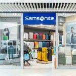 Widok na elegancki front salonu Samsonite. Nad wejściem widoczne jest prestiżowe, podświetlane logo marki.