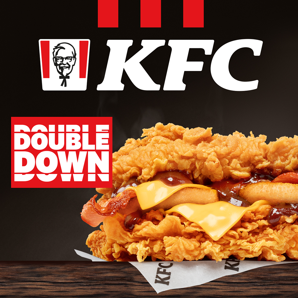 Grafika promocyjna przedstawiająca burgera Double Down (dwa kawałki kurczaka, ser i bekon) w restauracji KFC we Wrocławiu.