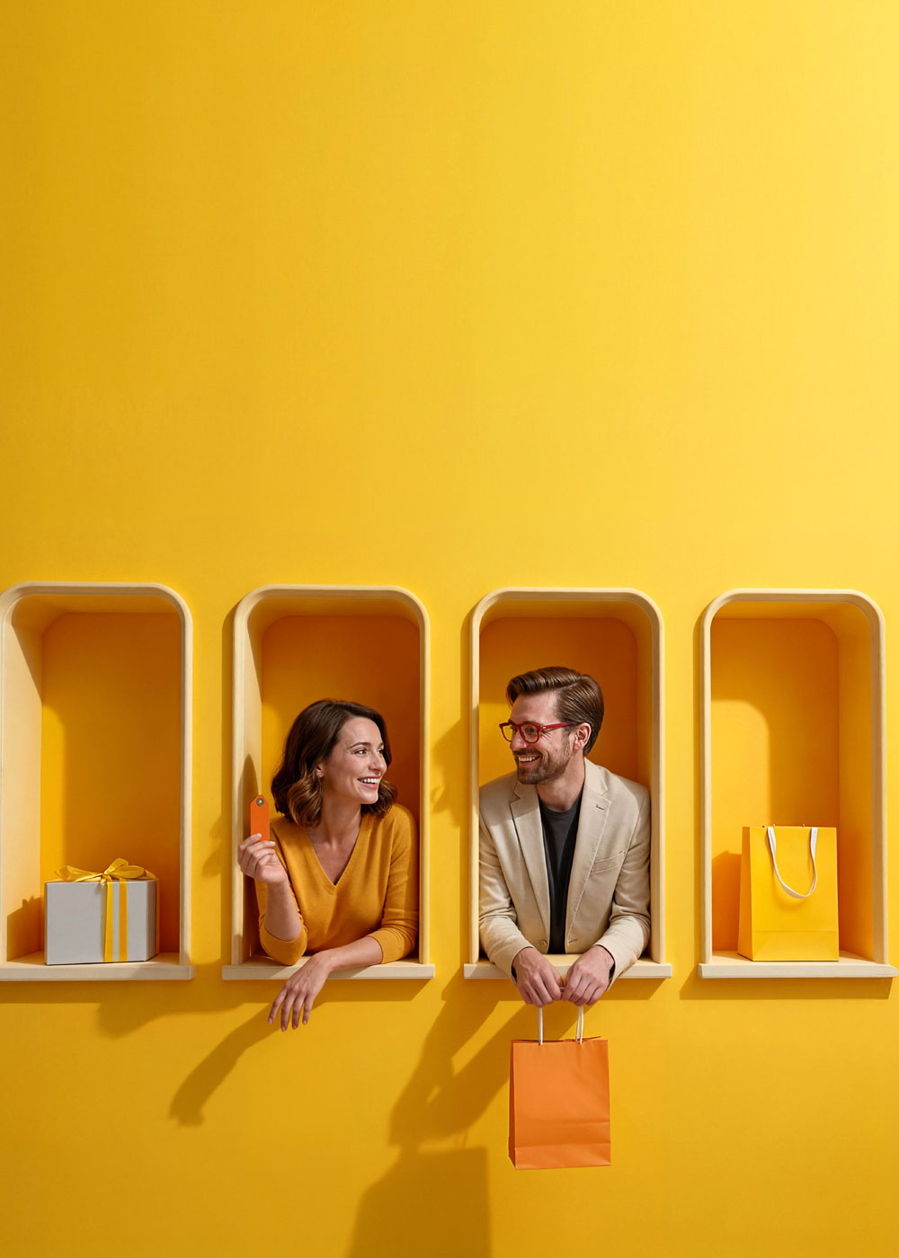 Kobieta z kartą płatniczą i mężczyzna z torbą zakupową wychylają się z dekoracyjnych żółtych wnęk; obok ustawione są torba zakupowa oraz pudełko prezentowe.
