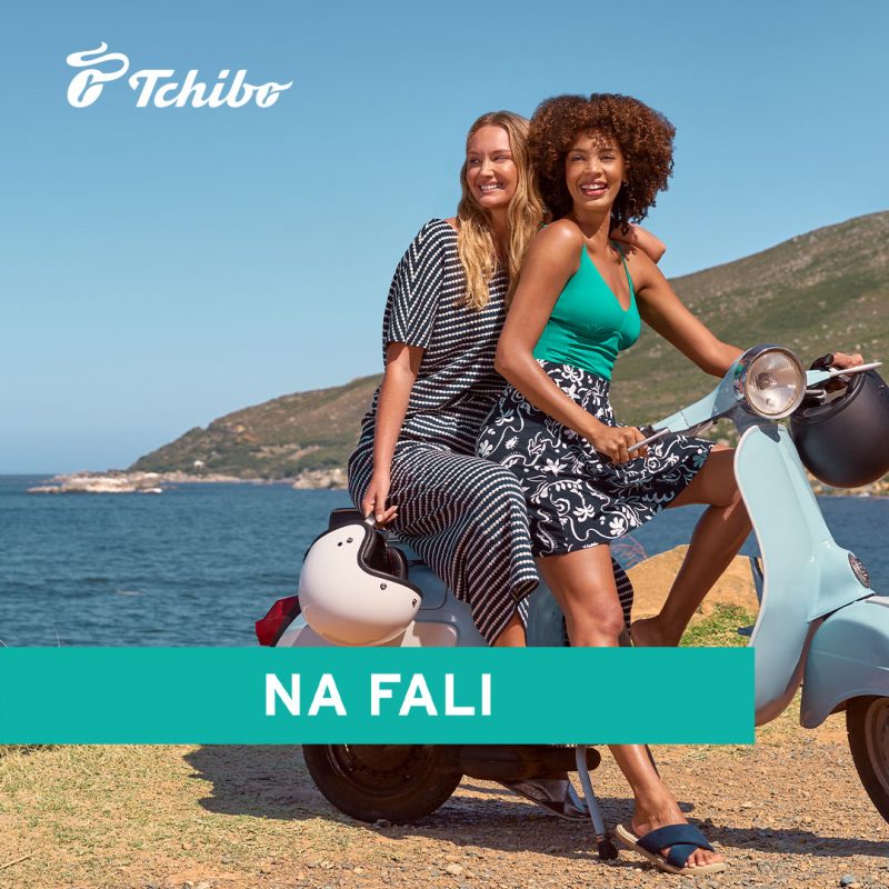 Plakat promocyjny z logo Tchibo i napisem Na Fali przedstawiający dwie kobiety w zwiewnych kreacjach na skuterze na plaży