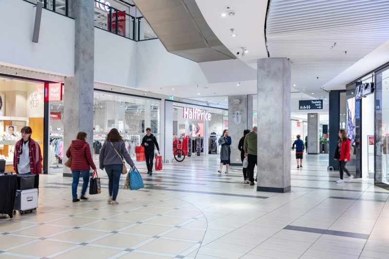 Zdjęcie przedstawia korytarz w Pasażu Grunwaldzkim we Wrocławiu. Widać ludzi chodzących po Galerii z zakupami.