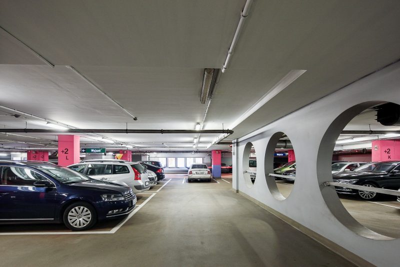 Parking w Galerii Pasaż Grunwaldzki we Wrocławiu. Po lewej stronie widać zaparkowane samochody.