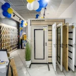 Wnętrze Studio Projektowego Castorama z ekspozycją drzwi wewnętrznych, stanowiskiem obsługi klienta oraz próbkami materiałów i dekoracji ściennych.