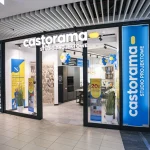 Nowoczesna, przeszklona witryna lokalu „Castorama – Studio Projektowe” w galerii handlowej. Nad wejściem widnieje podświetlony biały napis, a po prawej stronie usytuowano niebieski pionowy kaseton z logo.