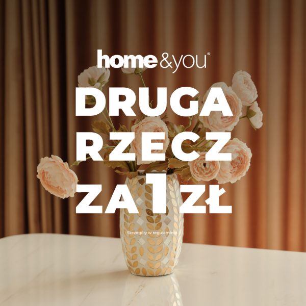 Grafika promocyjna marki home&you przedstawia jasny wazon w złote wzory z bukietem różowych kwiatów, stojący na białym stole na tle zasłon. Na obrazie umieszczono duży biały napis „DRUGA RZECZ ZA 1 ZŁ” oraz logo sklepu.