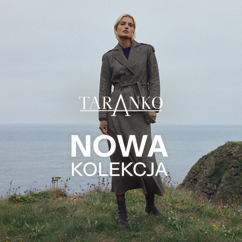 Kwadratowe zdjęcie wizerunkowe marki Taranko przedstawiające blond modelkę w długim, dwurzędowym płaszczu w kratkę stojącą na trawiastym klifie nad morzem. Na środku widnieje białe logo TARANKO oraz duży biały napis NOWA KOLEKCJA.