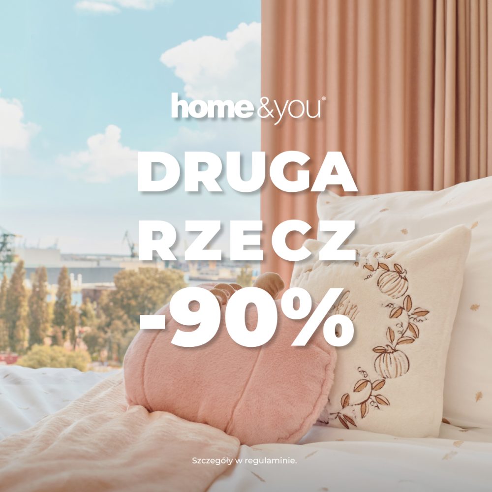 Kwadratowe zdjęcie promocyjne marki home&you pokazujące jasny i przytulny kadr sypialni. Na łóżku ułożona jest wzorzysta pościel, różowa narzuta oraz dekoracyjne poduszki w kształcie dyni. W tle widać okno z miejskim widokiem oraz beżową zasłonę. Na środku umieszczono logo home&you oraz napis DRUGA RZECZ -90%.