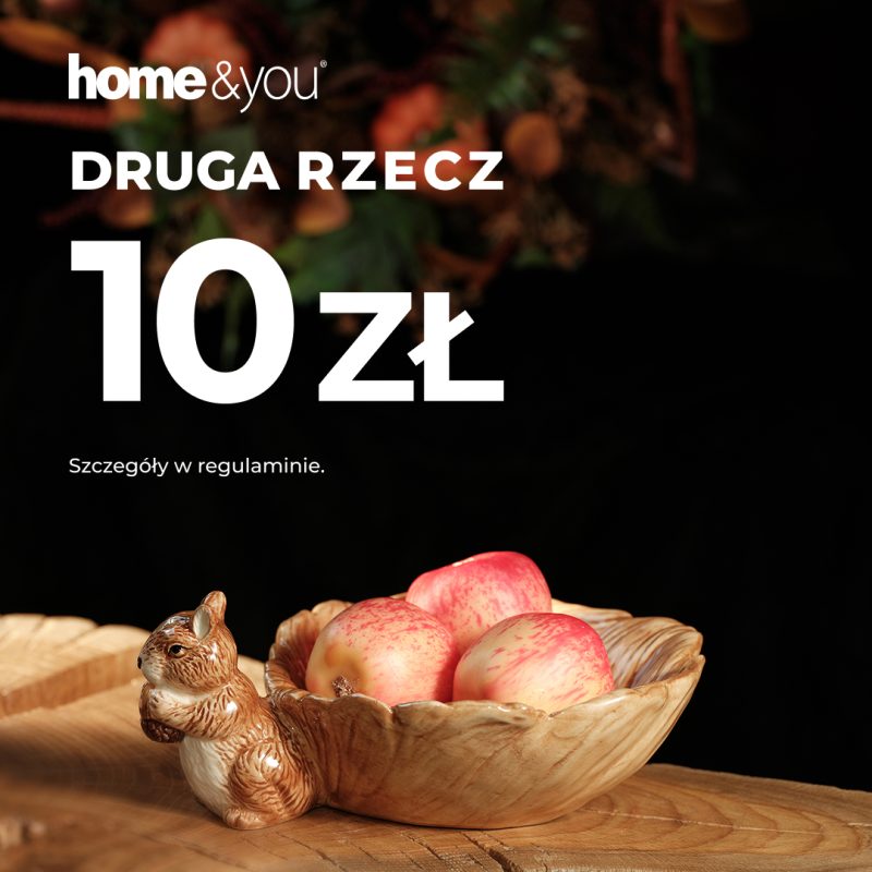 Kwadratowa fotografia promocyjna marki home&you przedstawiająca jesienną aranżację na drewnianym stole. Na pierwszym planie umieszczono ceramiczne naczynie w kształcie liścia z figurką wiewiórki wypełnione czerwonymi jabłkami oraz ozdobny pojemnik w kształcie żołędzia. W lewym górnym rogu znajduje się białe logo home&you oraz duży napis DRUGA RZECZ 10 zł i drobny tekst Szczegóły w regulaminie.
