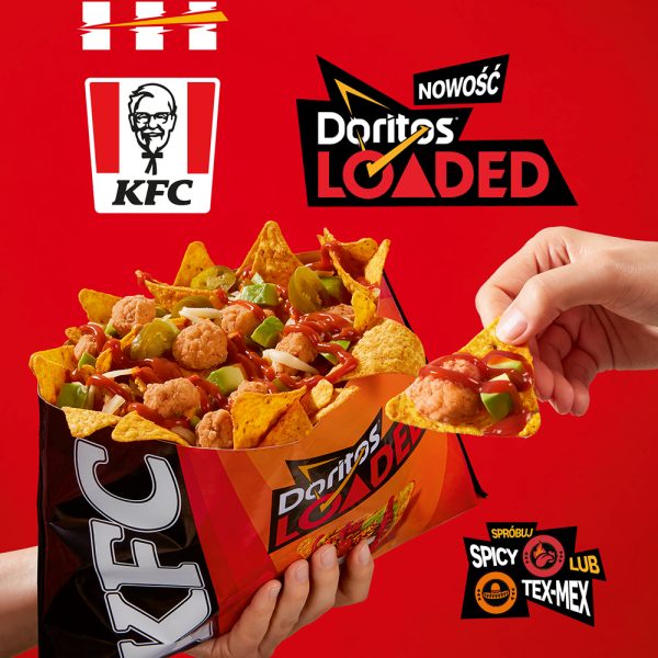 Czerwona kwadratowa grafika reklamowa marki KFC. Dwie dłonie trzymają czarno-pomarańczowe opakowanie Doritos Loaded wypełnione nachosami Doritos, kąskami Popcorn Chicken, krążkami jalapeño, cząstkami awokado i czerwonym sosem. W tle umieszczono białe logo KFC, logo NOWOŚĆ Doritos LOADED oraz czarno-czerwony napis SPRÓBUJ SPICY LUB TEX-MEX.