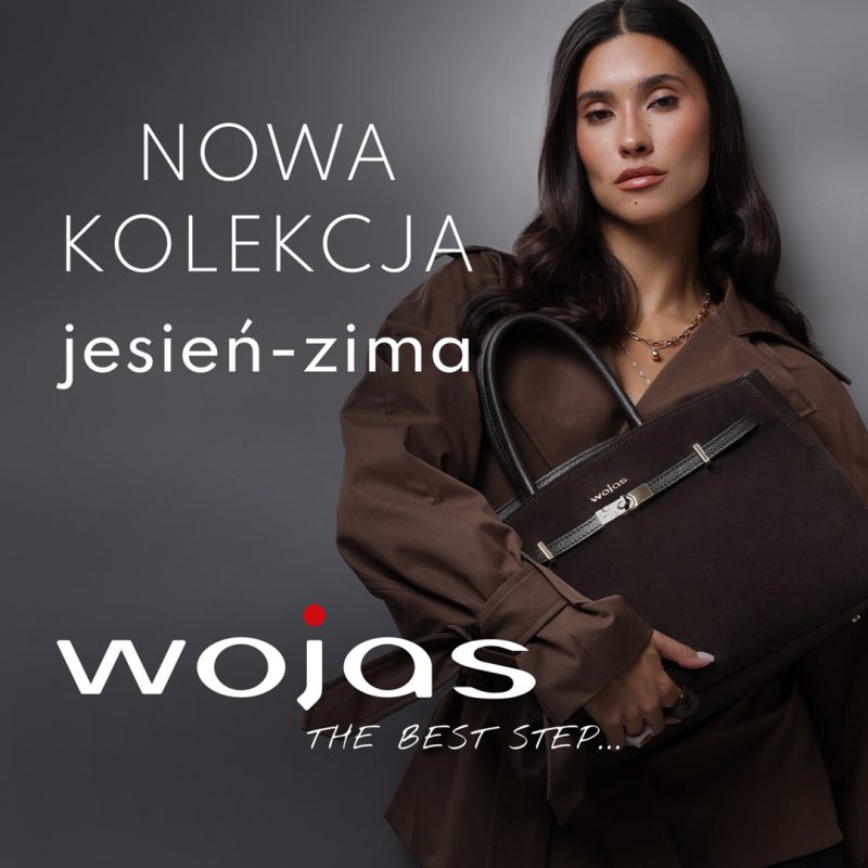 Kwadratowa fotografia reklamowa marki Wojas na szarym tle, przedstawiająca ciemnowłosą modelkę w brązowym płaszczu z paskiem, trzymającą dużą skórzaną torbę w odcieniu ciemnego brązu. Po lewej stronie umieszczono biały napis NOWA KOLEKCJA jesień-zima, a w dolnej części widnieje duże białe logo wojas z czerwoną kropką nad literą j oraz napisem THE BEST STEP....