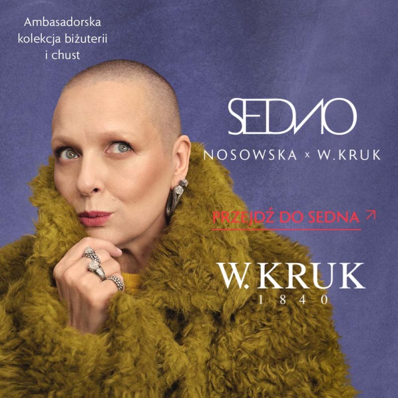 Portret Katarzyny Nosowskiej w zielonym puszystym okryciu, ozdobionej biżuterią z kolekcji SEDNO na fioletowym tle z logo W.KRUK w Pasażu Grunwaldzkim we Wrocławiu