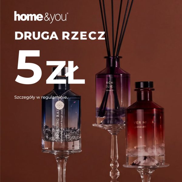 Trzy szklane dyfuzory zapachowe w kolorach granatowym, fioletowym i bordowym na kryształowych podstawkach, na brązowym tle z napisem „Druga rzecz 5 zł”