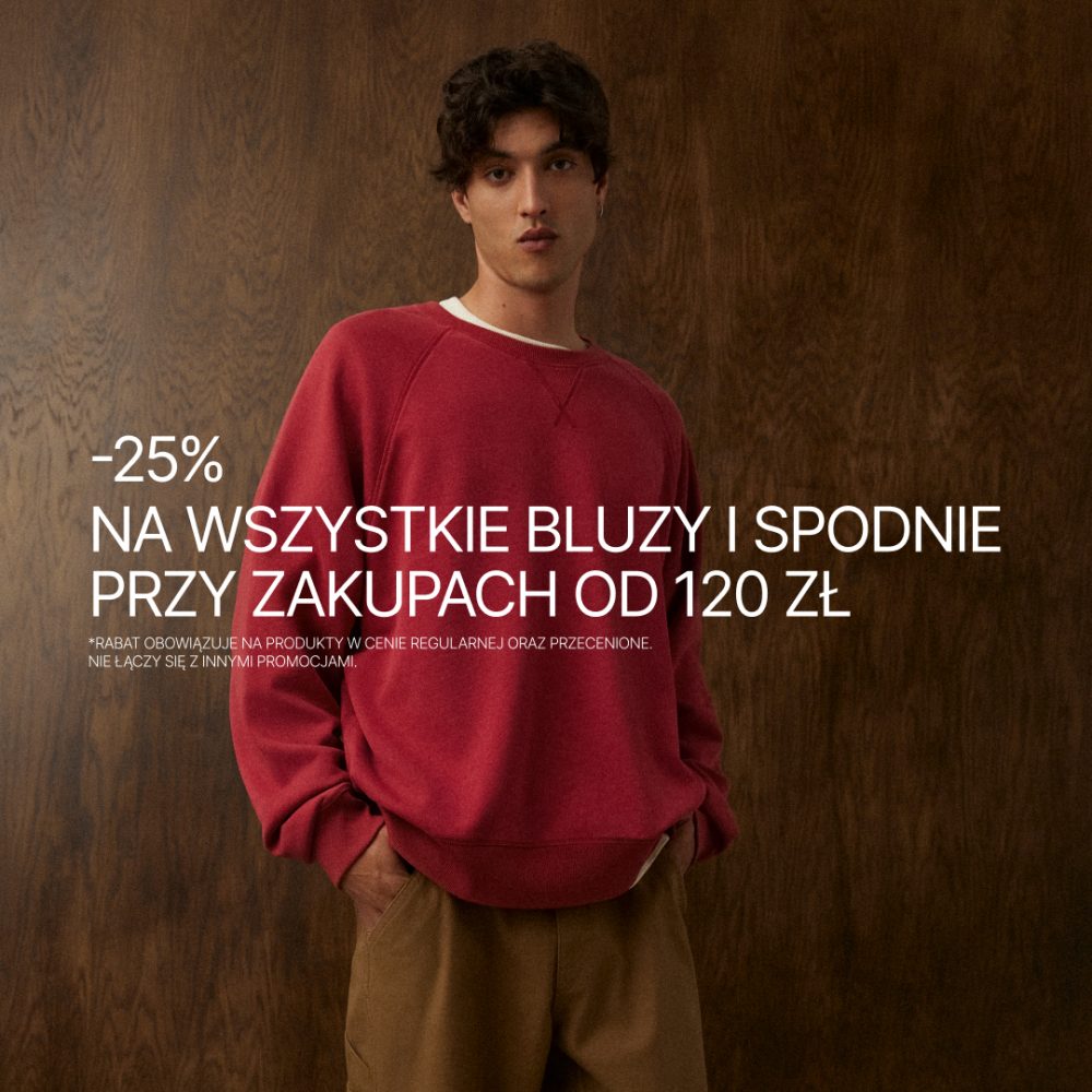 Grafika promocyjna marki Diverse informująca o ofercie rabatowej na bluzy i spodnie. Na zdjęciu widoczny jest młody model prezentujący czerwoną bluzę oraz brązowe spodnie na tle ciemnej, drewnianej ścianki. Po lewej stronie znajdują się białe napisy informujące o promocji: „-25% na wszystkie bluzy i spodnie przy zakupach od 120 zł” oraz dopisek drobnym drukiem zawierający warunki regulaminu.